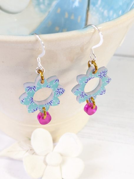 Pink & Blue Flower Earrings – 100% Recycled Green Cast Acrylic, Sterling Silver, by Amanda and Graham Cope Colourful flower-shaped earrings in pink and blue, handcrafted from Green Cast recycled acrylic and finished with a sterling silver hook.